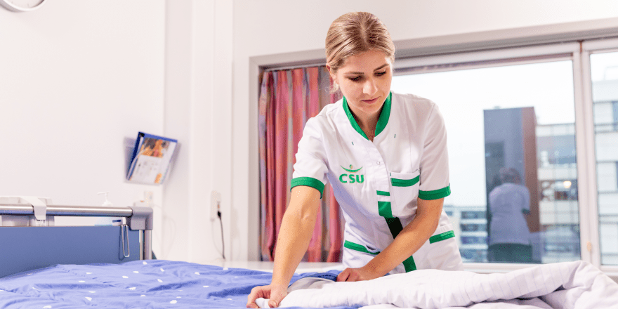 Csu medwerker die bed aan het opmaken is