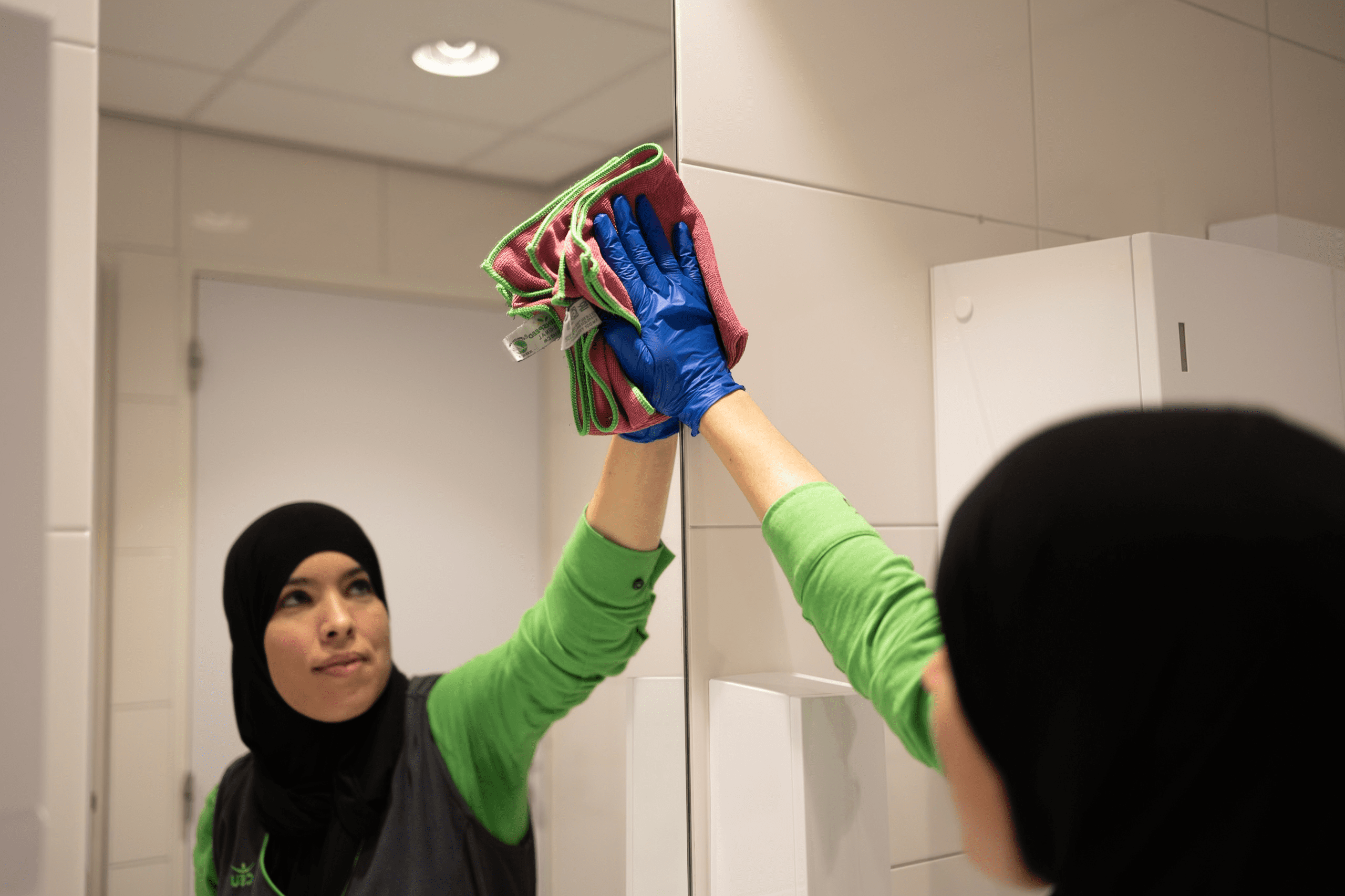 CSU medewerker die een spiegel aan het schoonmaken is